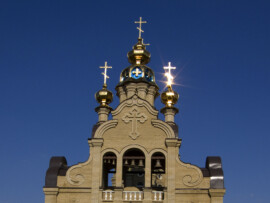 Das goldene Kreuz strahlt in der Sonne Strahlende goldene Kirchenzwiebel